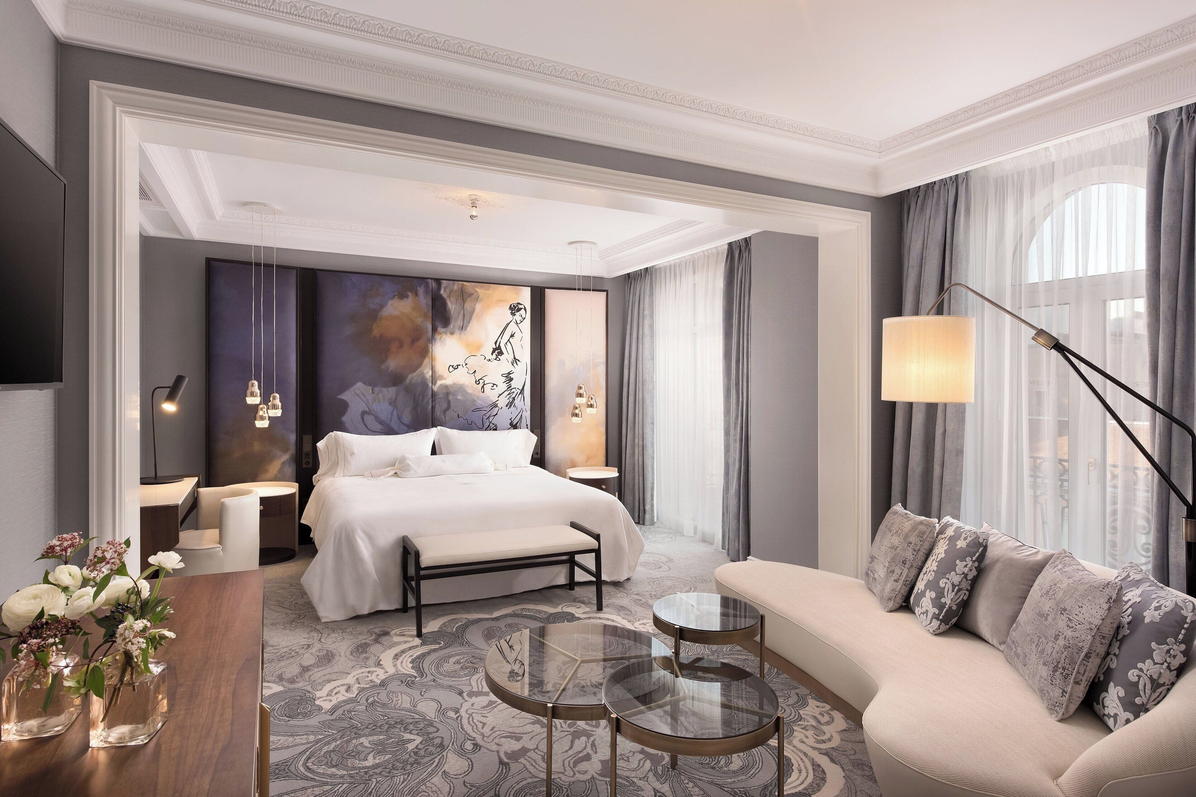 The Palace Madrid's Luxurious bedroom with a large bed, sofa, and decorative elements.
